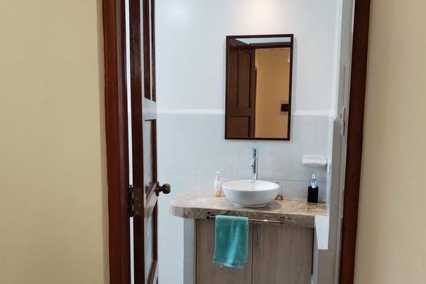 Baño compartido con lavamanos y espejo