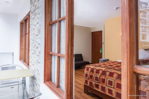 Habitación con ventanal y muro de piedra