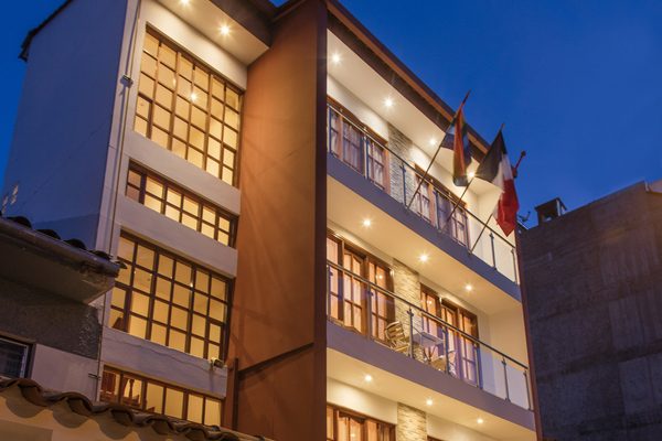 Fachada del Laramani Hotel Boutique iluminada al anochecer, Cusco