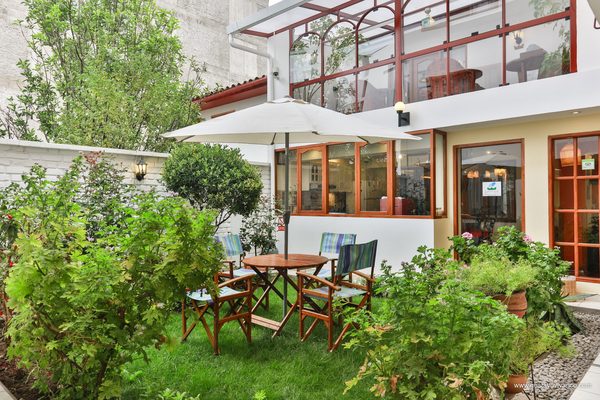 Jardín del hotel con mesa y sombrilla